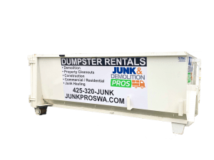 Junk-Pros-Dumpster Junk & Demolition Pros LLC's bright green 'Junk-Pros-Dumpster' placed at a home renovation site, filled with construction debris and old furniture