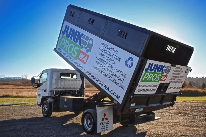Junk Pros truck tipping its cargo box to unload a haul