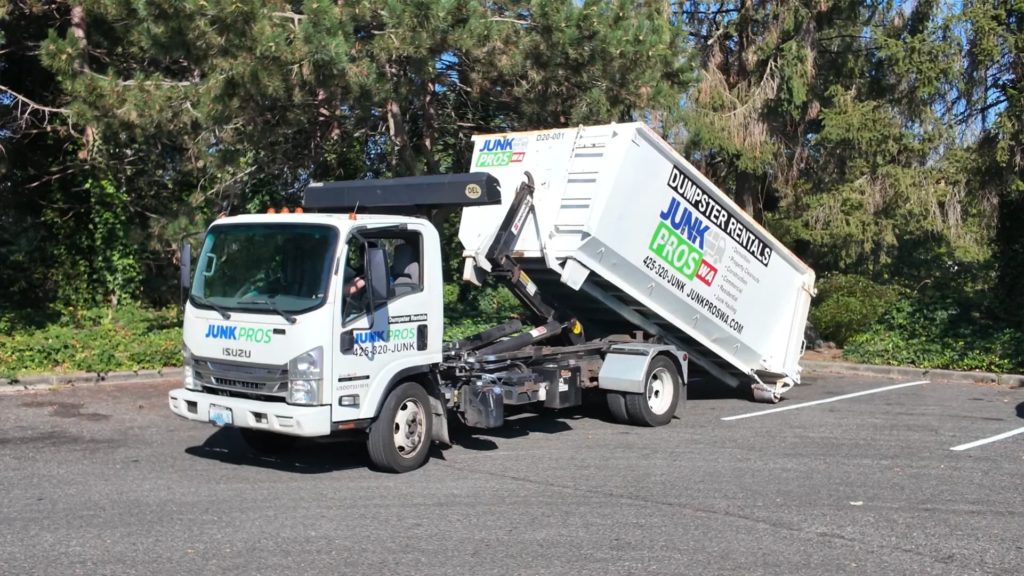 Junk Pros roll-off truck carrying a Dumpster Rentals container
