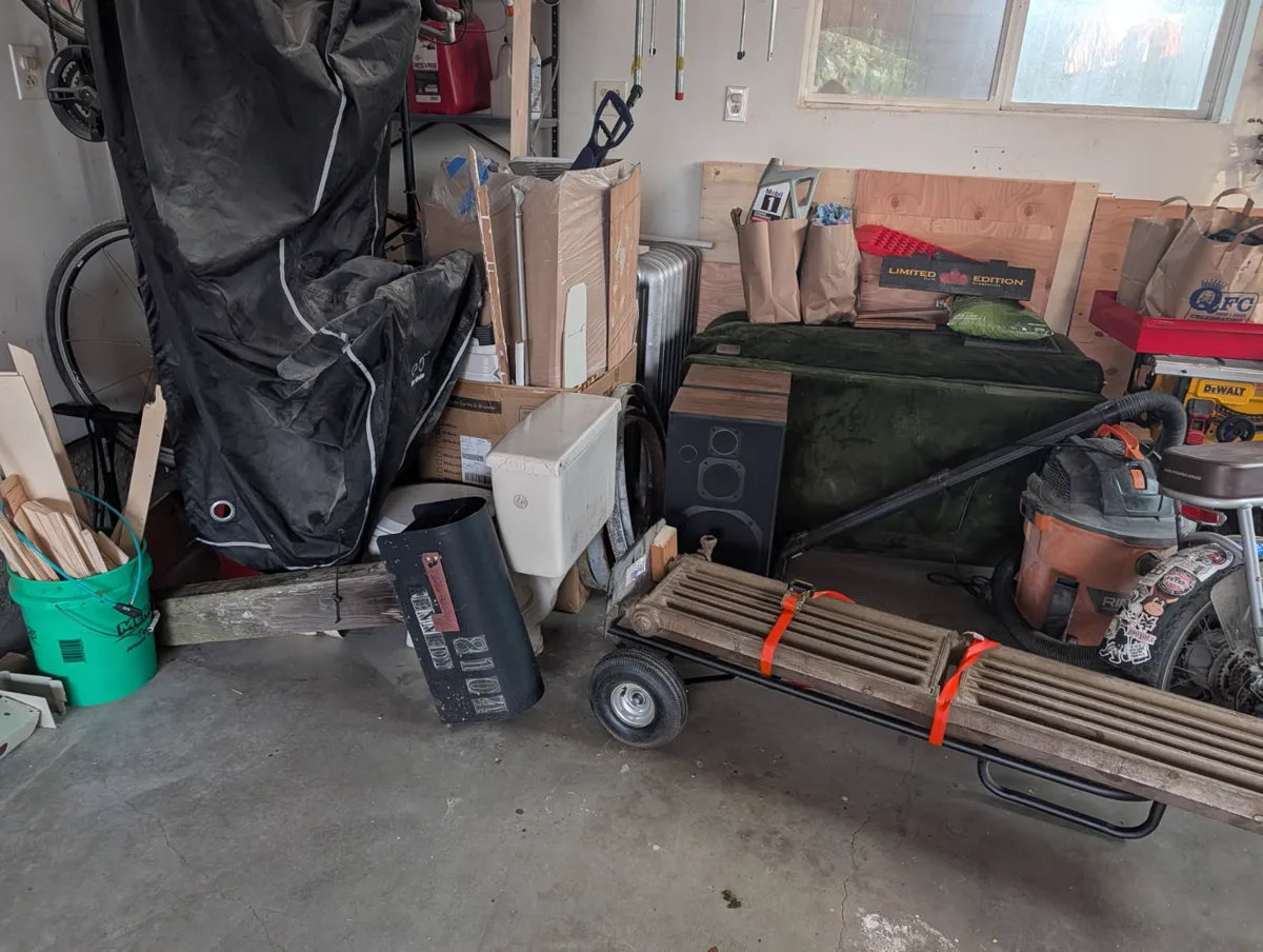 Garage with a toilet, radiator, shop vacuum, and other bulky items for removal