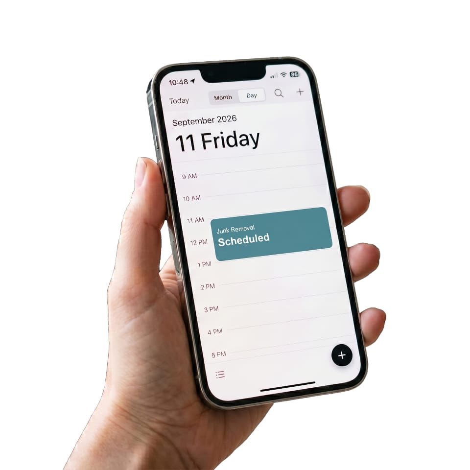 a person scheduling junk removal on their mobile phone.