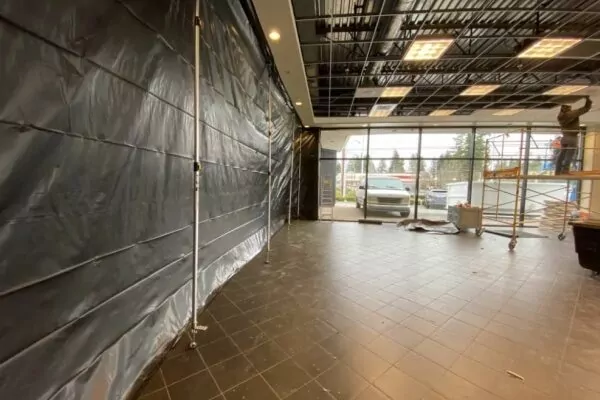 Commercial showroom with plastic containment sheeting set up for interior demolition
